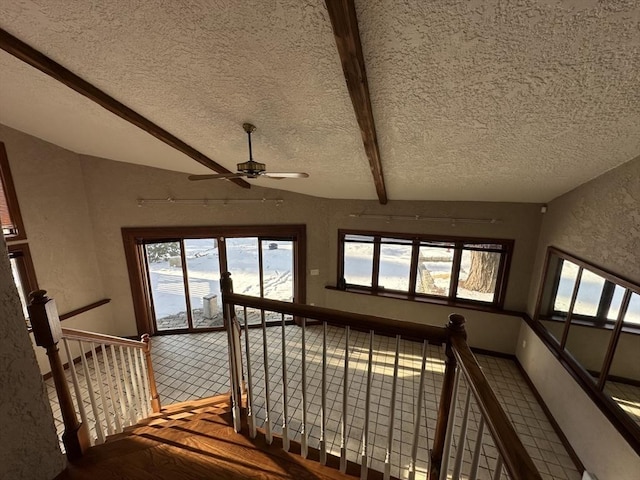 stairs with hardwood / wood-style floors, a textured ceiling, and vaulted ceiling with beams