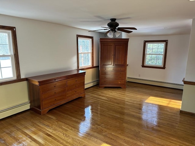 unfurnished bedroom with hardwood / wood-style flooring, ceiling fan, and baseboard heating