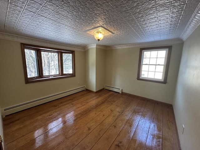 spare room with a baseboard radiator, ornamental molding, and plenty of natural light