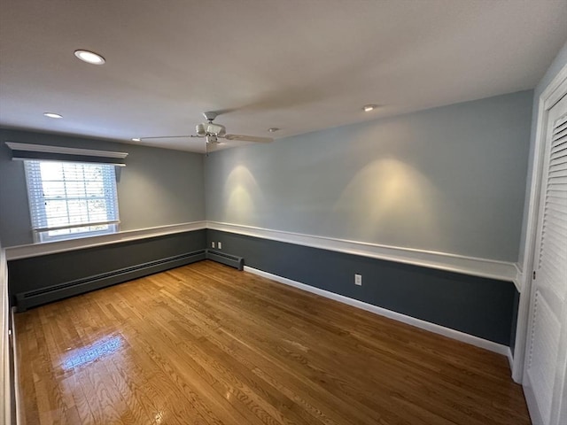 empty room with baseboard heating, ceiling fan, and hardwood / wood-style floors