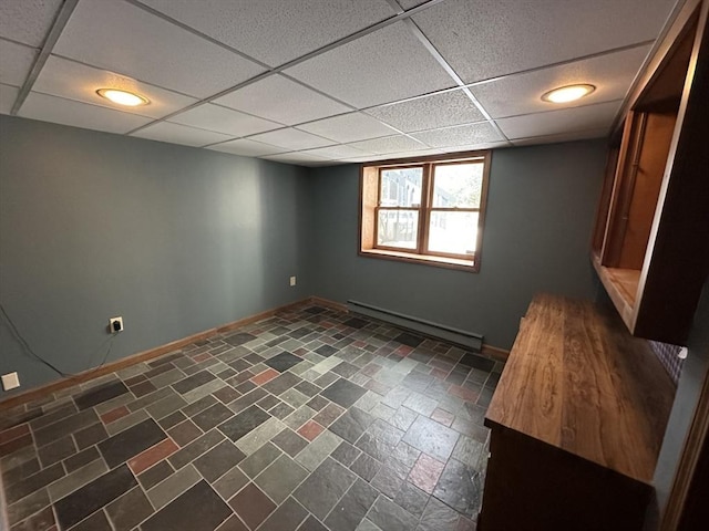 basement with a drop ceiling and a baseboard heating unit