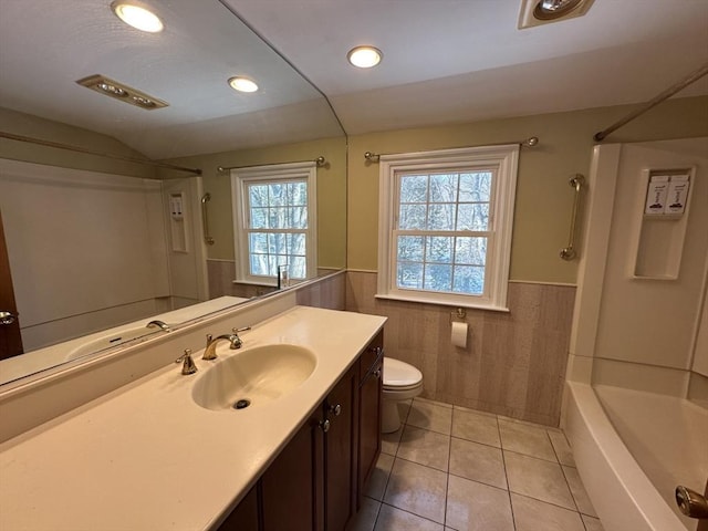 full bathroom featuring tile walls, vanity, toilet, tub / shower combination, and tile patterned floors