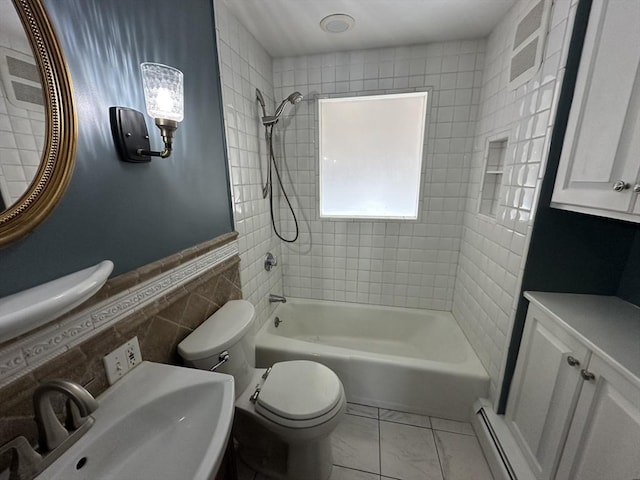 full bathroom featuring tiled shower / bath, sink, tile walls, a baseboard heating unit, and toilet