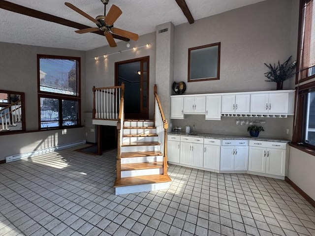 kitchen featuring white cabinetry, tasteful backsplash, a textured ceiling, light tile patterned floors, and ceiling fan