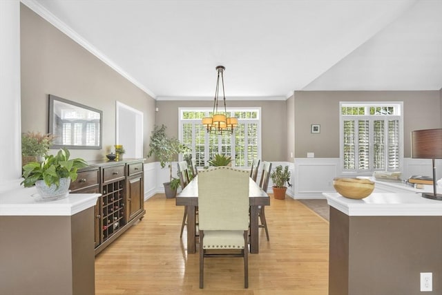18 Preserve Way, Sturbridge, MA 01566 - dining room featuring light wood-style floors, a chandelier, a decorative wall, crown molding, and a wainscoted wall