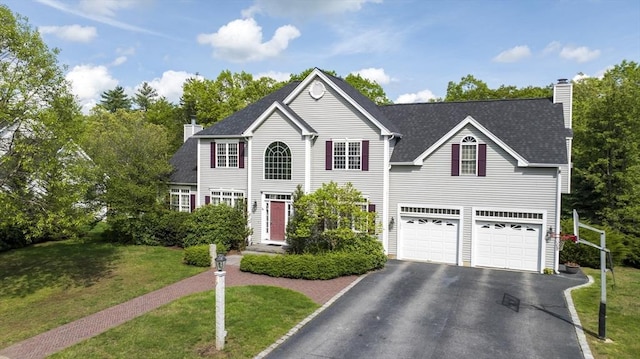 18 Preserve Way, Sturbridge, MA 01566 - colonial-style house featuring a chimney, driveway, a front yard, and an attached garage