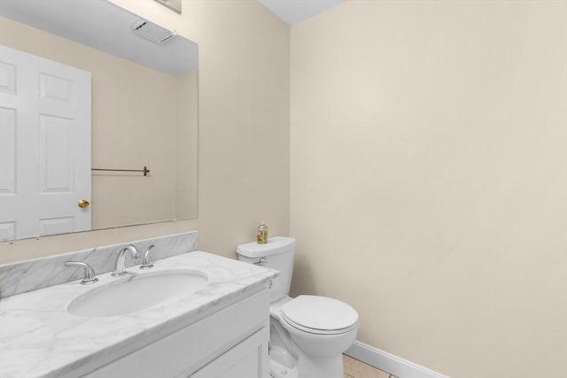 half bathroom featuring toilet, vanity, and tile patterned flooring