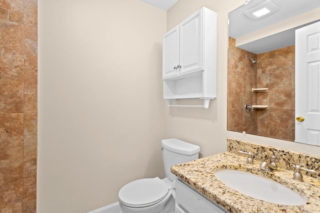 full bath with a tile shower, toilet, and vanity