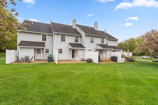 back of house with a patio area, central AC unit, and a chimney