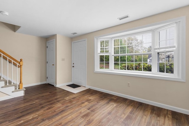 foyer with baseboards, wood finished floors, and stairway