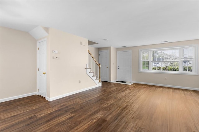 unfurnished living room with stairway, baseboards, and wood finished floors