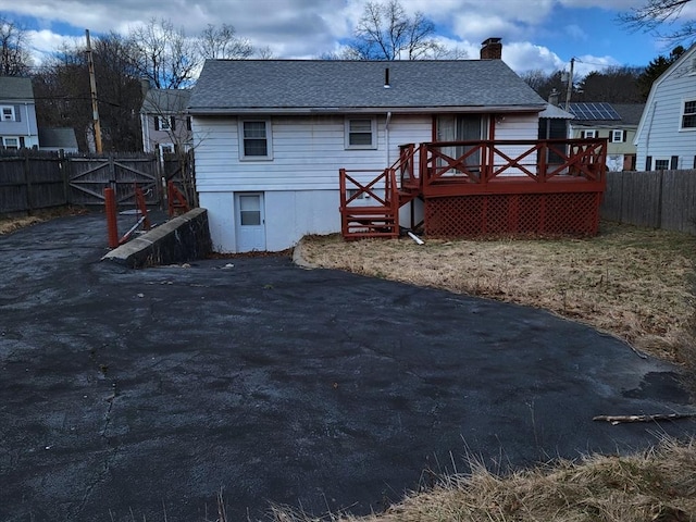 24 Neillian Cres, Boston, MA 02130 - back of property featuring a deck, a chimney, fence, and roof with shingles