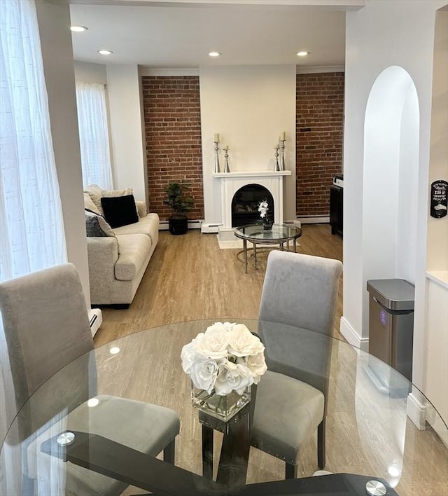 living room featuring hardwood / wood-style floors, a baseboard radiator, and a fireplace