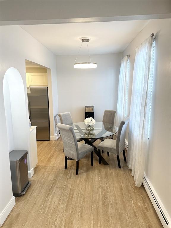 dining area with baseboard heating and light hardwood / wood-style floors