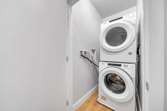 191 Washington St Unit 318, Boston, MA 02135 - washroom featuring stacked washing machine and dryer, light wood finished floors, and baseboards