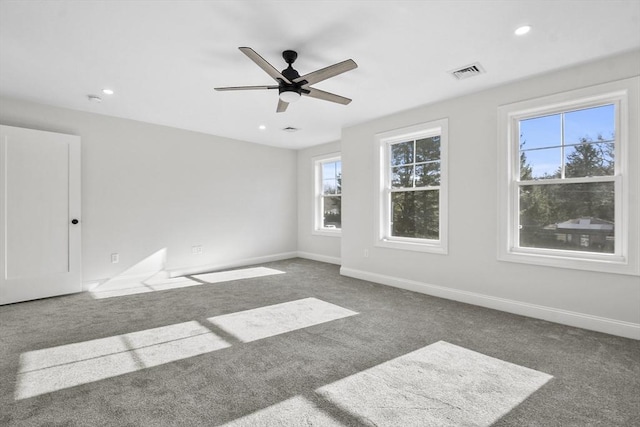 spare room featuring ceiling fan and dark carpet