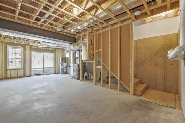 miscellaneous room with heating unit, water heater, and concrete floors