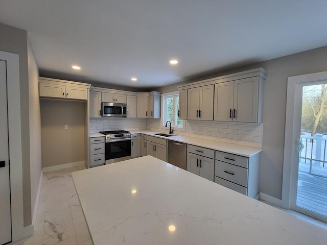 kitchen featuring tasteful backsplash, appliances with stainless steel finishes, sink, and gray cabinetry