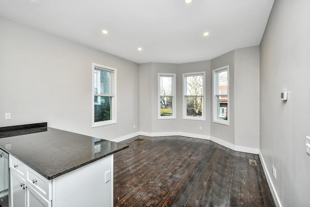 interior space featuring white cabinets, dark hardwood / wood-style floors, and dark stone countertops