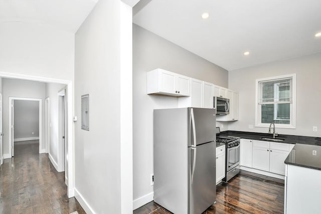 kitchen featuring dark hardwood / wood-style floors, appliances with stainless steel finishes, white cabinets, and sink