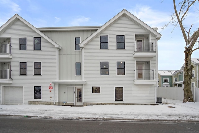 view of front of home featuring a balcony, a garage, and central AC