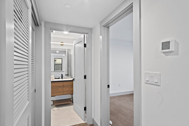 hall featuring light wood-type flooring and sink