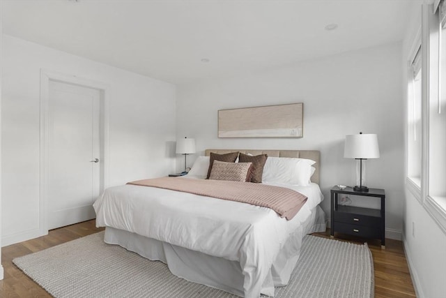 bedroom with wood-type flooring and multiple windows