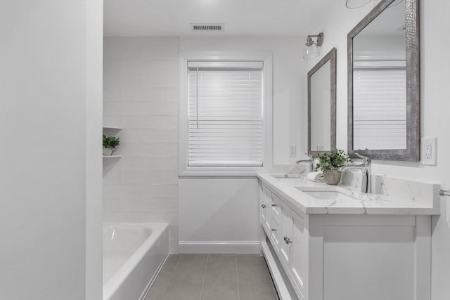 bathroom featuring tile patterned flooring, vanity, and a bathing tub