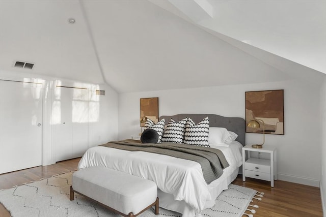 bedroom featuring hardwood / wood-style flooring and lofted ceiling