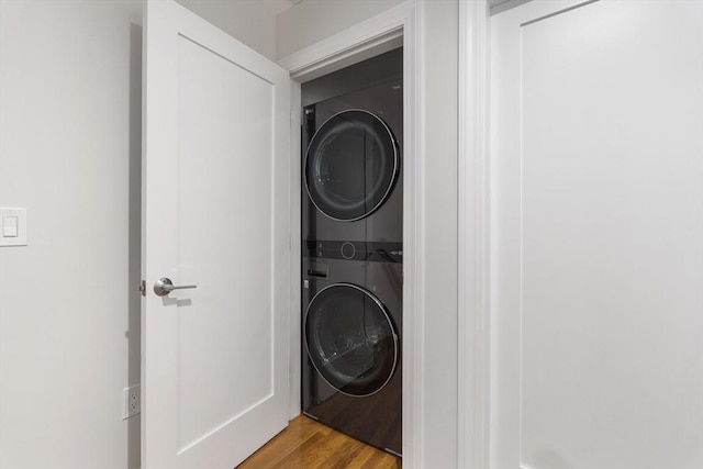 laundry area with light wood-type flooring and stacked washer and clothes dryer