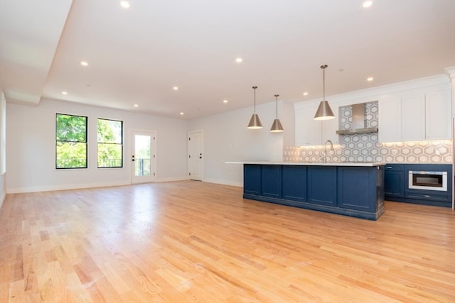 kitchen with light wood-type flooring, backsplash, blue cabinetry, and white cabinets