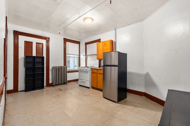 kitchen with stainless steel refrigerator, radiator, and white gas range oven