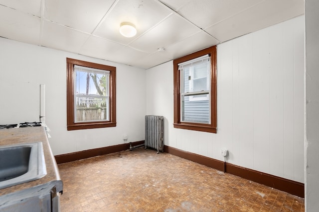 kitchen with a paneled ceiling, radiator, and sink