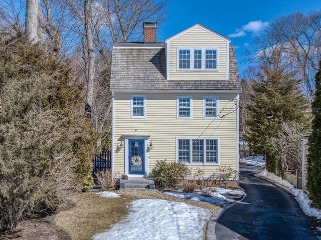 view of front of home featuring driveway and a chimney