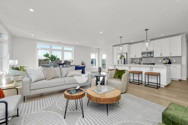 living room with sink and light hardwood / wood-style floors