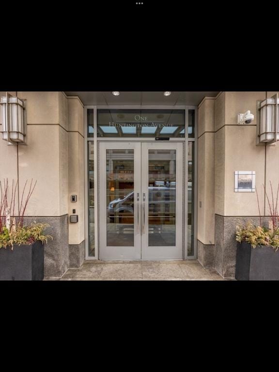 doorway to property featuring french doors and stucco siding