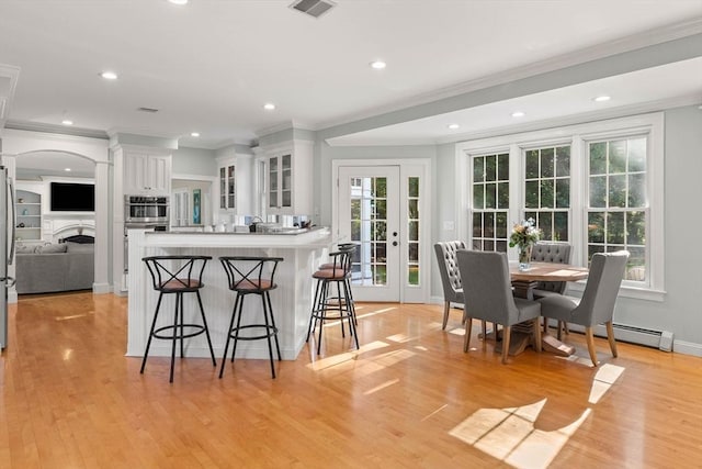 kitchen with white cabinetry, ornamental molding, and a kitchen breakfast bar