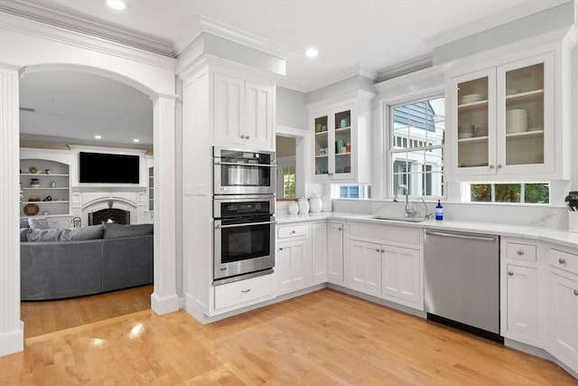 kitchen featuring sink, ornamental molding, white cabinets, and appliances with stainless steel finishes