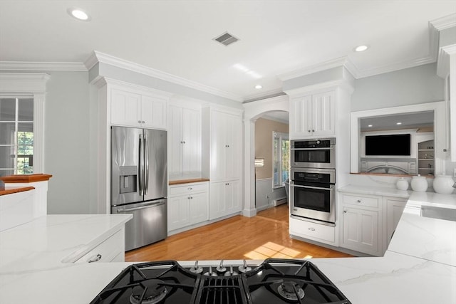 kitchen with white cabinetry, light stone counters, and appliances with stainless steel finishes