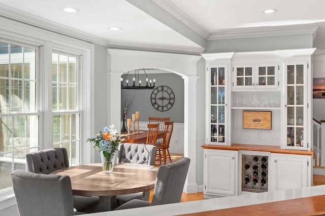 dining room with decorative columns, ornamental molding, and a chandelier