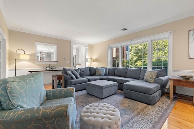 living room with wood-type flooring and ornamental molding