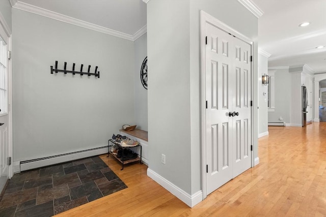 corridor featuring ornamental molding, hardwood / wood-style floors, and a baseboard heating unit