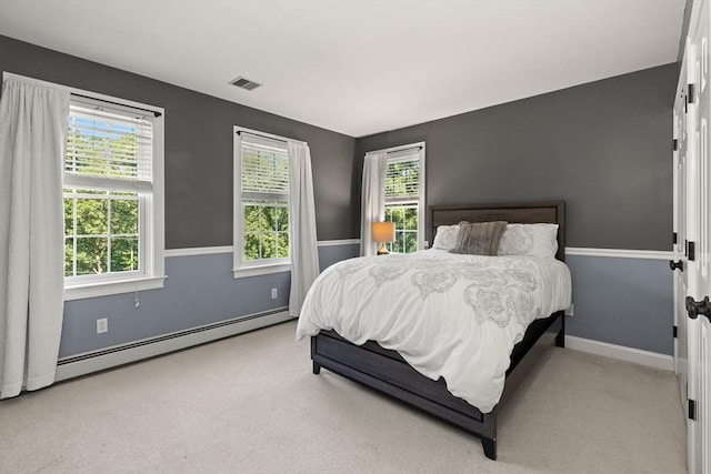 carpeted bedroom with multiple windows and a baseboard radiator