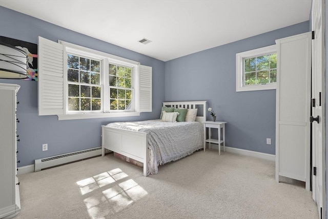 bedroom with a baseboard radiator, light carpet, and multiple windows