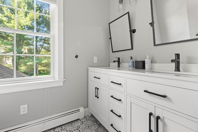 bathroom with tile patterned floors, a healthy amount of sunlight, vanity, and a baseboard heating unit