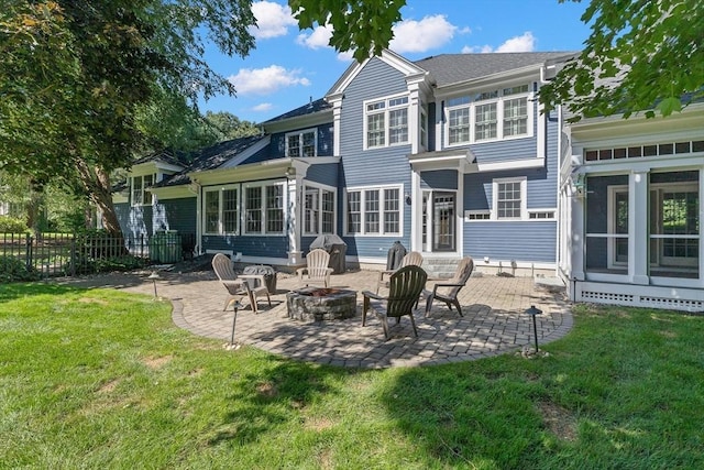 back of property featuring a yard, a patio, and an outdoor fire pit