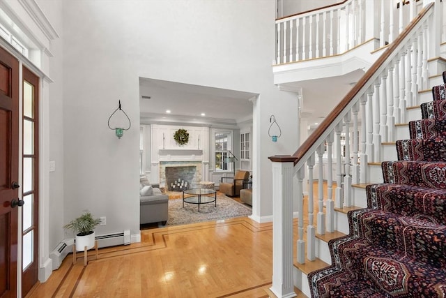 entryway featuring a fireplace, light hardwood / wood-style flooring, a healthy amount of sunlight, and baseboard heating