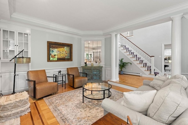 living room with ornate columns, a baseboard radiator, and crown molding