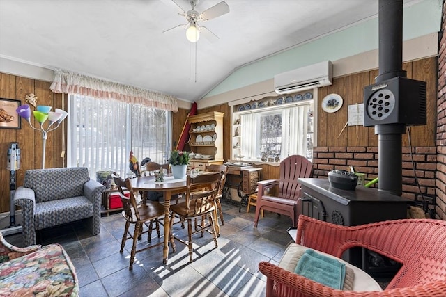 dining area with a wood stove, wood walls, and a wall mounted AC