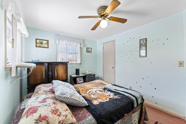 carpeted bedroom featuring a ceiling fan and baseboards